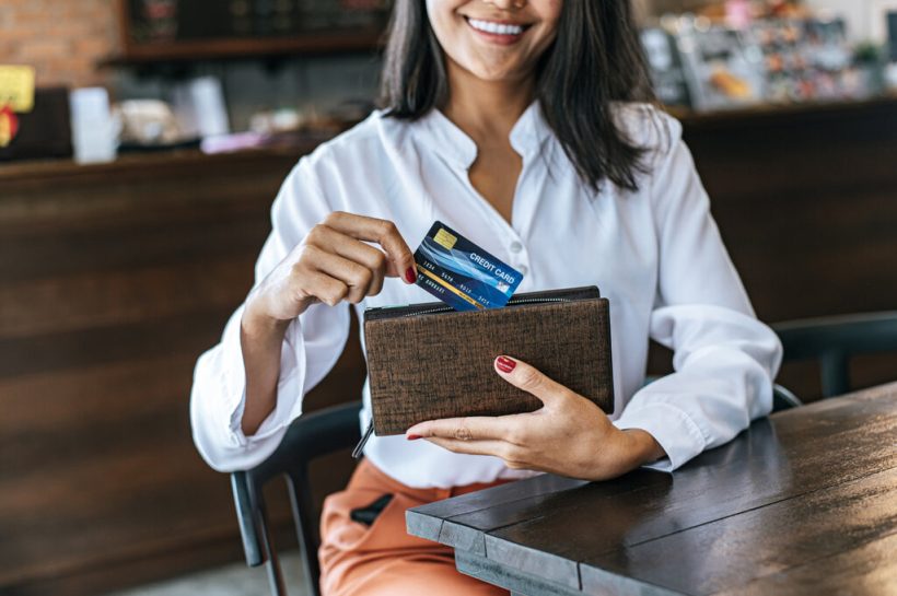 Mujer sonriente con su tarjeta de crédito