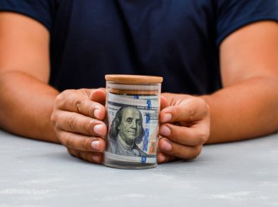 hombre mostrando dinero en un tarro