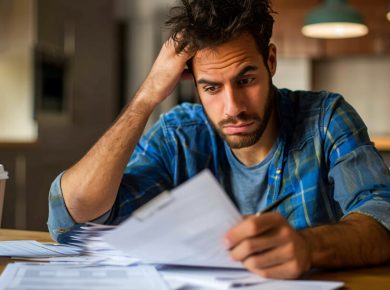 hombre preocupado revisando sus finanzas