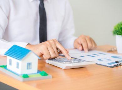 hombre utilizando calculadora para revisar sus finanzas