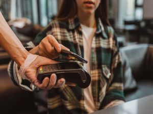 mujer pagando un consumo con su celular en el pos