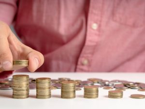 primer plano de un hombre colocando monedas en fila