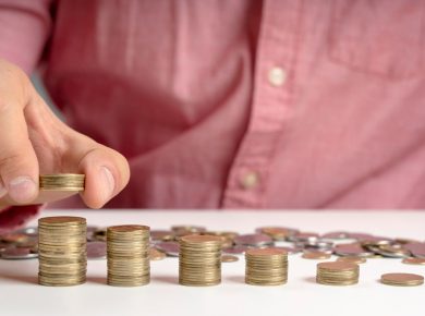 primer plano de un hombre colocando monedas en fila